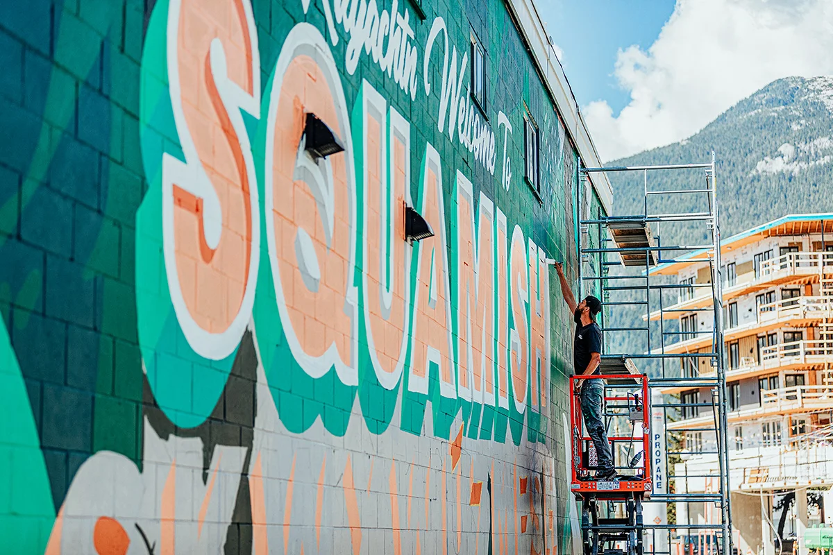 https://www.downtownsquamish.com/wp-content/uploads/2024/06/Squamish-Public-Art-Welcome-to-Squamish-Mural-Alex-Fowkes2.jpg.webp